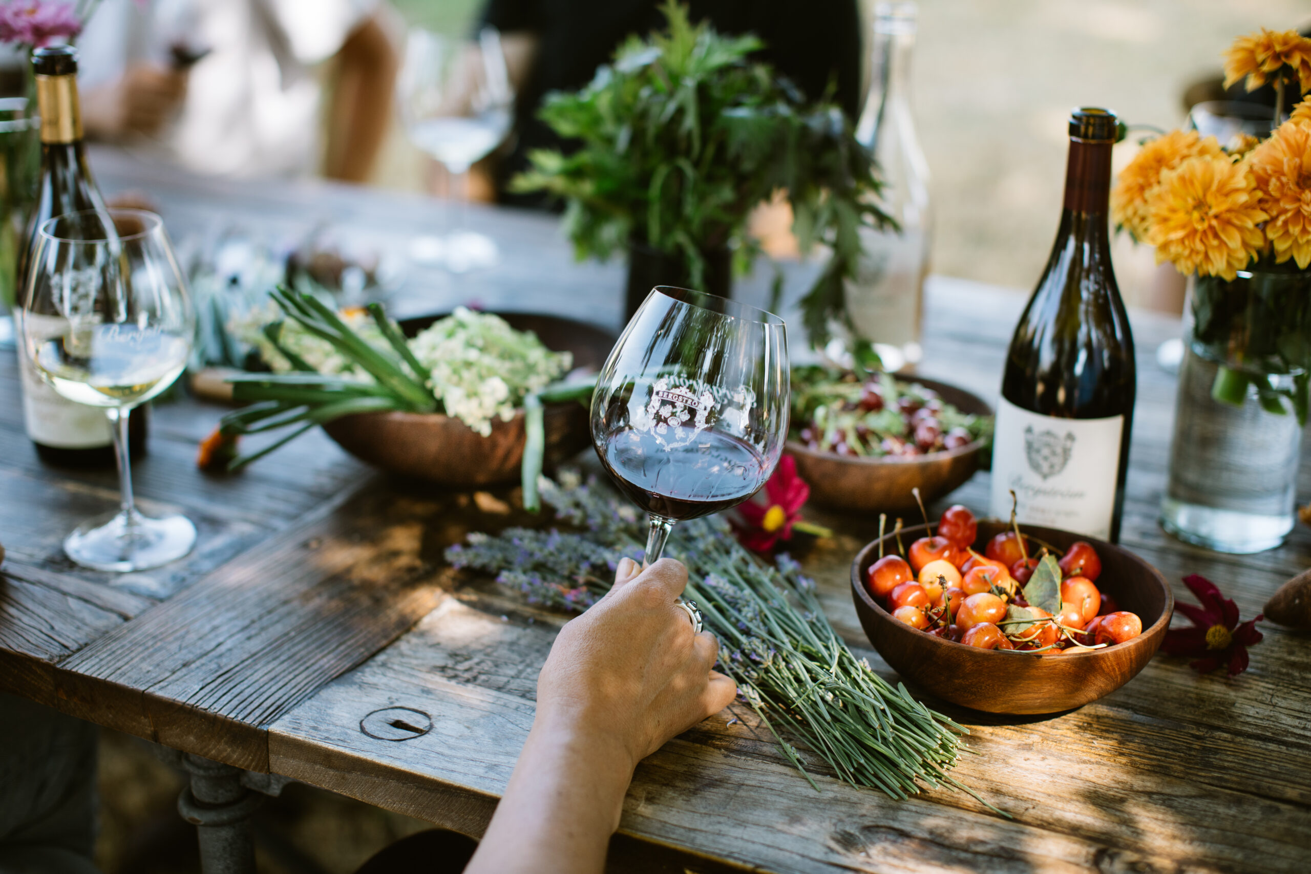 Glassofwine-holdingglassangled-red-legs-bottle-lavender-cherries-darker